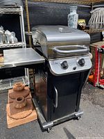 Full view of mini Char-Broil gas grill including side shelf, wheels, and front control panel in an outdoor setting.