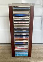 Full view of the wooden CD tower fully loaded with CDs showing the front spines of the CDs