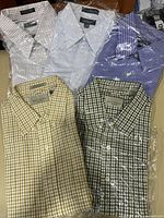 Five folded Bill Blass button-down shirts in assorted checked patterns and colors, wrapped in plastic.