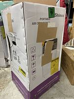Box of Shinco portable air conditioner showing brand, condition, and product details.