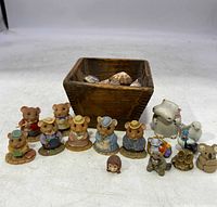 All miniature animal figurines and the wooden trinket box with shells arranged on a white surface