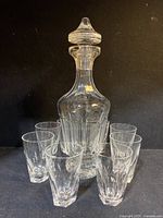 Full set with decanter centered and eight glasses surrounding it showing set composition and condition.