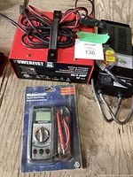 Powerfist battery charger, Mastercraft digital multimeter in packaging, MotoMaster battery tester with cables seen partially