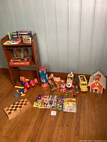 Full view of all items in collection arranged on floor and shelf including toys, comics, abacus, and boxed games