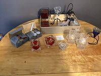 Overview of all items including candle holders, candles, and tea light boxes on wood table.
