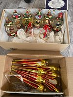 Full boxed set of glass globe figurine Christmas ornaments and packaged elongated glass icicles