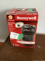 Front view of Honeywell heater box showing branding and features like fan forced heater, 360° surround heat, and medium room suitability
