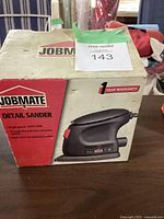 Box packaging showing brand Jobmate and product details including single speed 12000 OPM, through-the-pad dust extraction, and hook and loop fastening system.