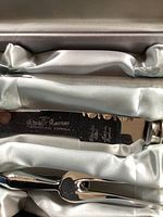 Close-up photo of engraving on serrated stainless steel carving knife showing King Karver branding and faux antler handle.