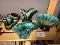 Photo showing entire set including 4 mugs, leaf-shaped vase, ashtray, and pedestal bowl with green and black Mid-Century Modern glaze.