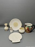 Full view of six porcelain items arranged including two pitchers, two bowls, one vase, and one shell plate