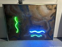 Full view of the mixed-media painting showing textured paint surface with green and blue neon lights forming wavy lines.