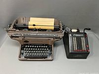 Underwood typewriter and Corona adding machine together showing size and condition.