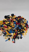 Top view of large pile of assorted LEGO bricks, plates, and parts in various colors on white background.