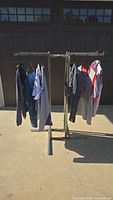 Full view of all 7 women's clothing items hung on a metal rack outdoors.