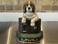 Front view of the antique style cast iron dog doorstop showing the dog atop a wooden gate base