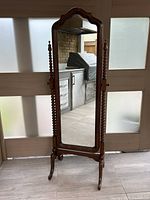 Full front view of cheval mirror showing scalloped top and full-length mirror