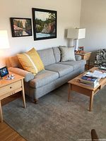 Full view of sofa in living room with side tables and decorative pillows