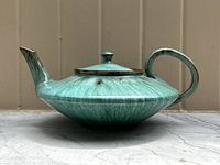 Blue Mountain Pottery teapot with green glaze, showing side profile