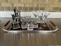 Full view of entire cocktail lot on tray showing glasses, bar tools, and shaker