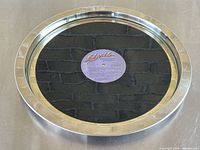 Top view of silver metal tray with glass cover showing purple Elvis Presley record label in center