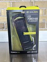 Front of box showing the Goal Zero Torch 250 USB Power Hub plus Flashlight in packaging.