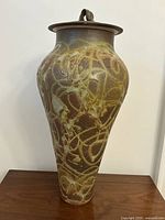 Full front view of the tall urn with lid in place