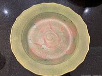 Top-down view showing scalloped rim and abstract apple motif
