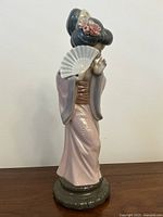 Side view of Lladro Geisha figurine showing pink kimono and fan