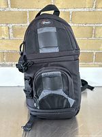 Front view of black Lowepro camera backpack showing top handle, zippers and front compartments