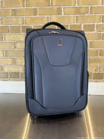 Front view of the Travelpro carryon suitcase showing the main zippered pocket, front panel design, and brand logo.