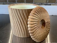 Front angle showing bucket body and removable lid with twisted carved wood pattern.