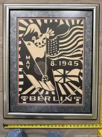 Full front view of the framed artwork showing black and beige depiction of flags, dove and date "May 8, 1945" with Berlin text at bottom.