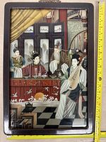 Full view of framed Asian artwork with measuring tape to show size
