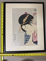 Full view of framed art print showing female in blue and red kimono with fans, ruler for size reference.