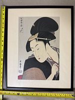Full view of framed artwork showing woman in kimono with measuring tape showing approximately 20 inches tall and 16 inches wide