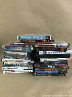 Stacked DVDs showing titles including Inside Tea Party's, Mighty Pirates Complete Series, The Rocky School Collection, The Sweeney, Zulu, Brian's Song, Angela with Dirty Faces.