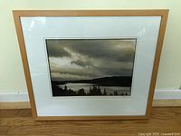 Framed photograph showing the full artwork with light wood frame and white mat.