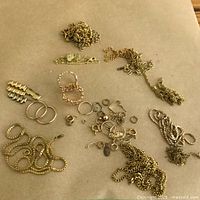 Loose jumble of chains, rings and findings on paper background