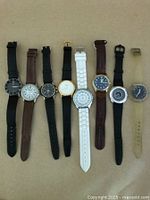 Photo showing all eight wristwatches arranged in a row, depicting size, band types, and face designs.