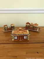 Front view of all pieces including the covered butter dish and two trays with spice containers