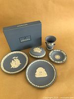 Lot layout showing three Jasperware plates, covered dish, vase, and Wedgwood box on neutral background