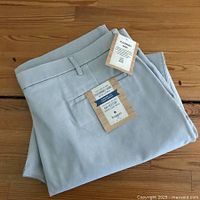 Folded view of the light gray Haggar performance khaki pants with visible tags showing brand and size information.