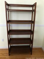 Front view of the solid wood étagère showing five shelves with varying heights and open design.