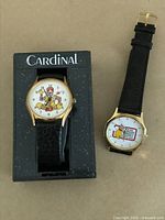 Two McDonald's watches side by side, one in a Cardinal branded case and one loose, both showing Ronald McDonald designs on the dials.