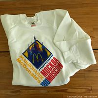 Front view of white sweatshirt folded, showing McDonald's Moscow 1990 bright front print with Russian text and St. Basil's Cathedral stylized graphic.