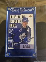 Front of 1993-94 Upper Deck Hockey #306 Doug Gilmour Team Points Leader card in hard plastic case.