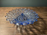 Side angle shot showing the scalloped edge detail and the patterned design of the blue glass bowl.