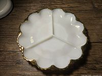 Top view of the white milk glass divided dish showing three compartments and scalloped gold-trimmed edge.