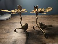 Pair of vintage brass taper candle holders with birds, branches, leaves, and flower-shaped candle cups.